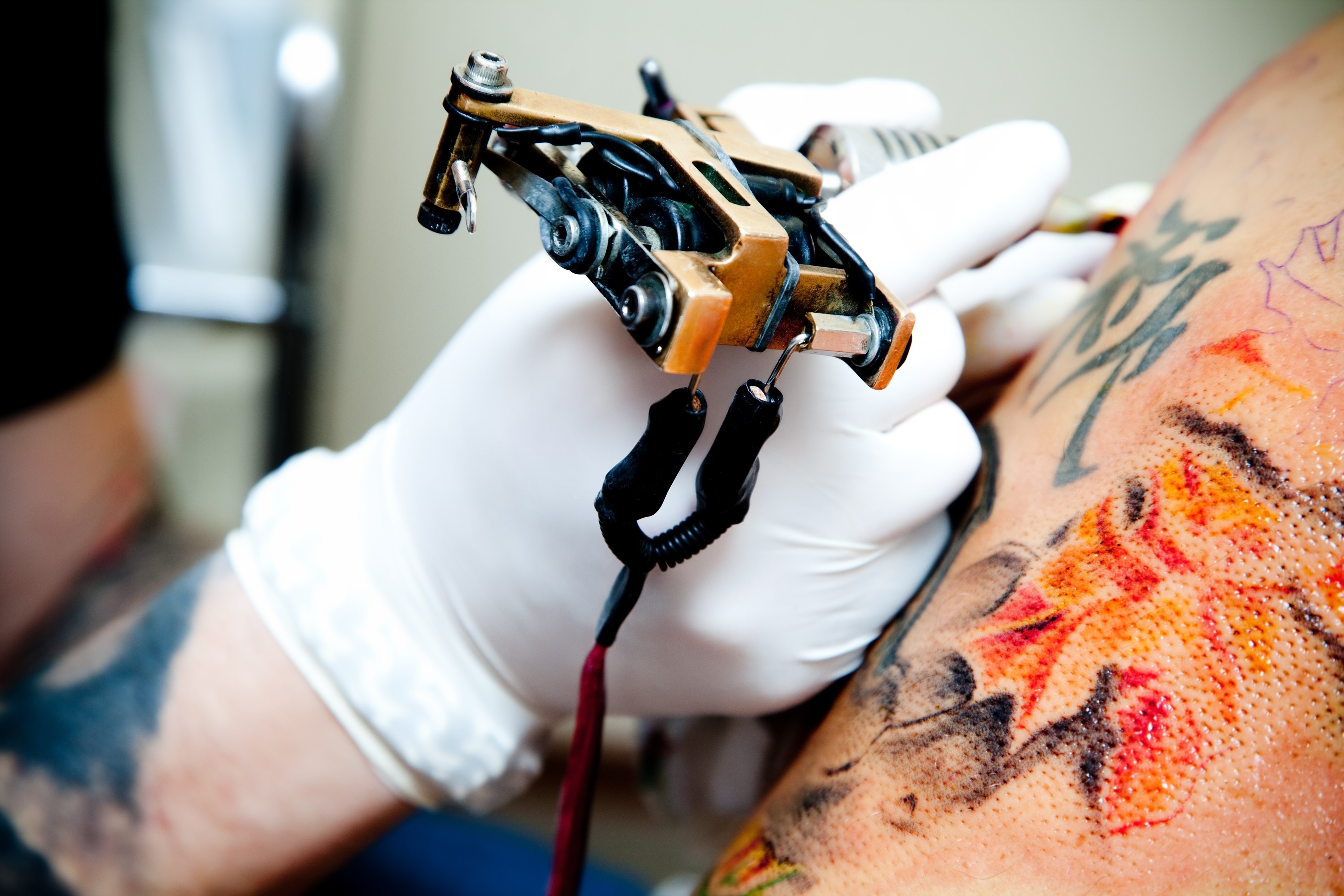 Tattoo artist working on client