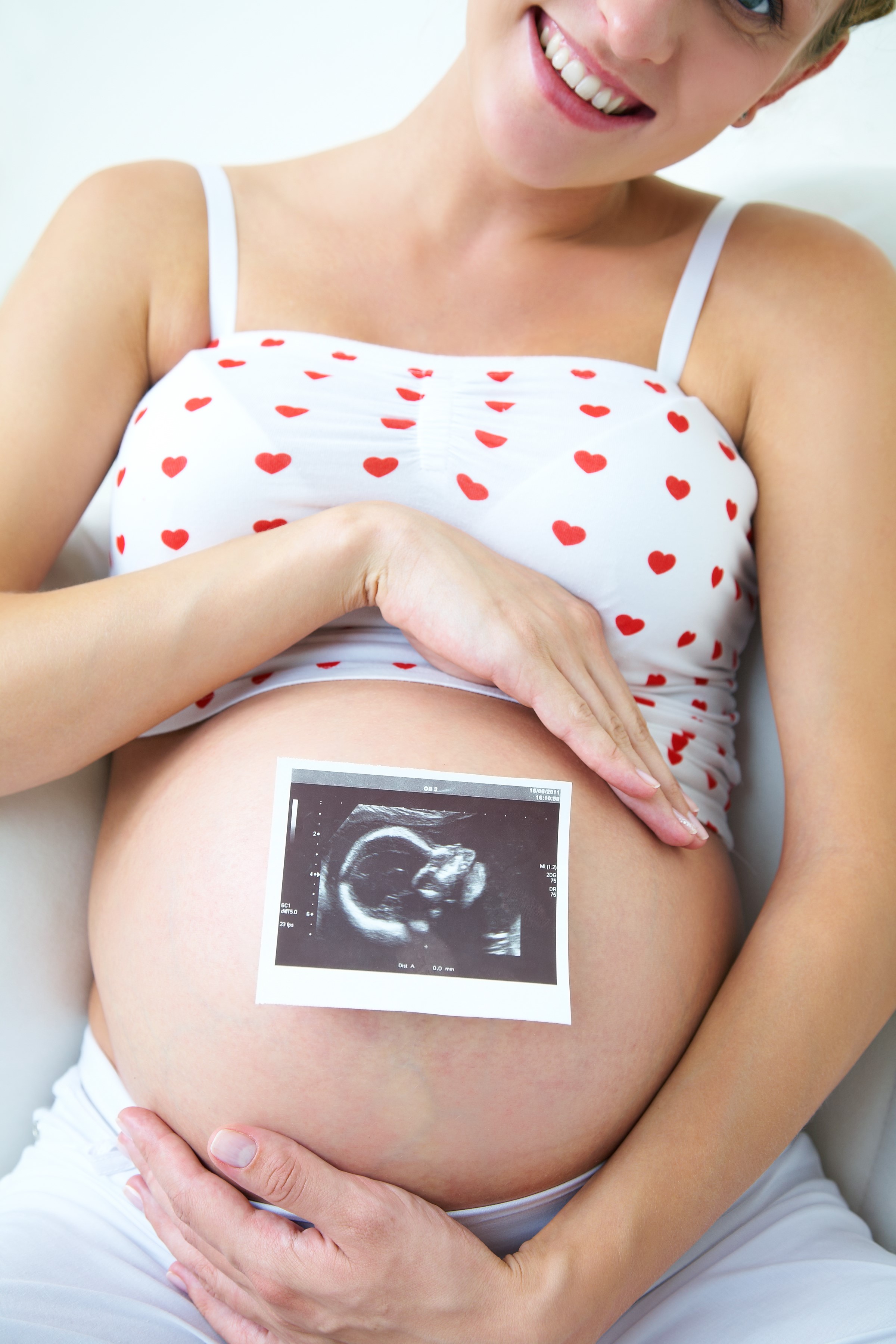 Pregnant woman holding ultrasound picture her baby