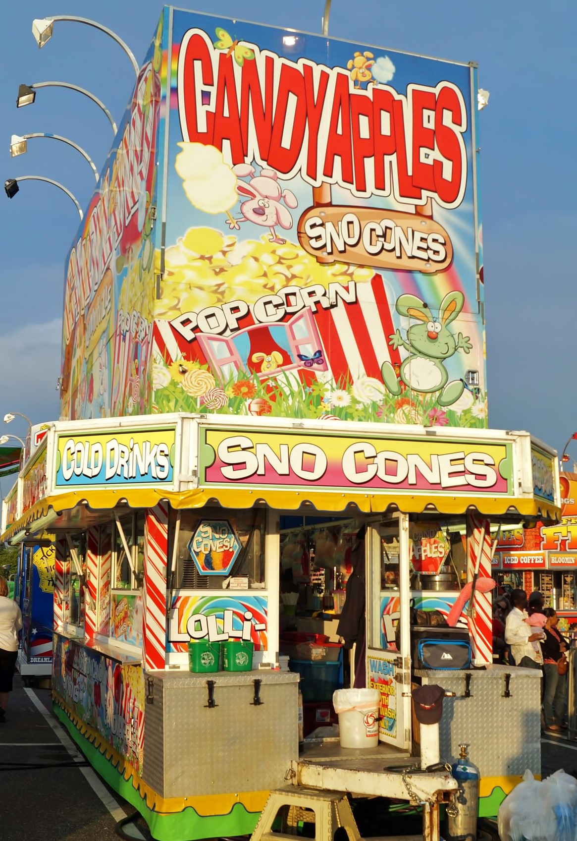 People wait in line to buy snack food at a traveling summer carnival.
