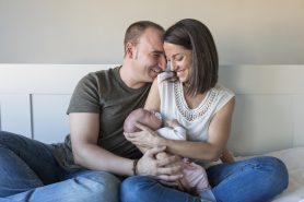 happy mother and father with her baby girl at home.